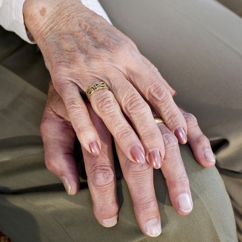 Goldene Hochzeit: Eine alte Frauenhand mit Ehering auf einer Männerhand