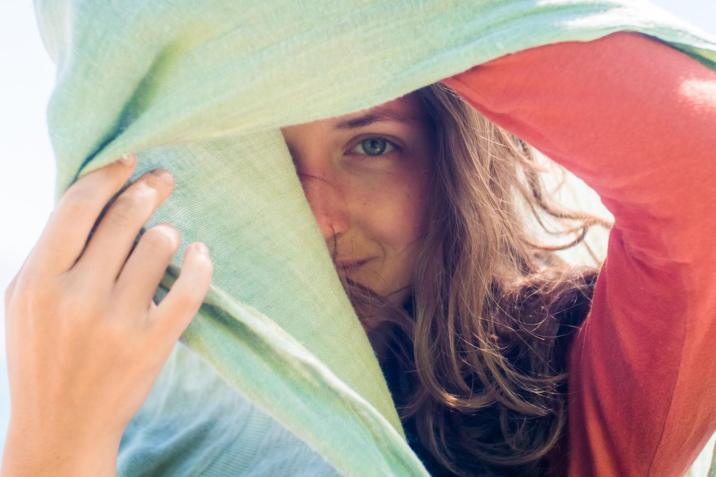 Wann sind Selbstzweifel gut? Eine Frau versteckt sich halb hinter einem Tuch