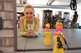 Kraftquellen der Redaktion: Eine junge Frau macht ein Spiegelselfie im Fitnessstudio