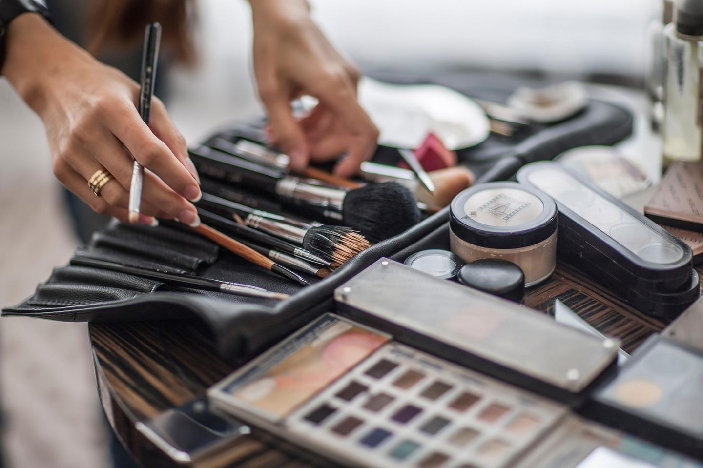 Make-up auffrischen: Make-up-Artist mit Pinseln in der Hand