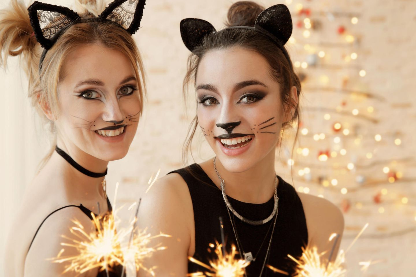 Als Katze schminken: Zwei Frauen im Katzen-Look und Wunderkerzen