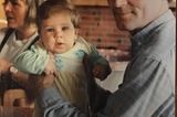 Kraftquellen der Redaktion: Ein attraktiver Mann hält ein Baby in die Kamera