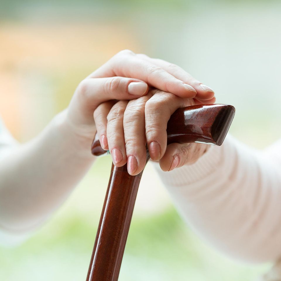 Mehr Geld für soziale Berufe: Pflegerin hält die Hand einer alten Frau