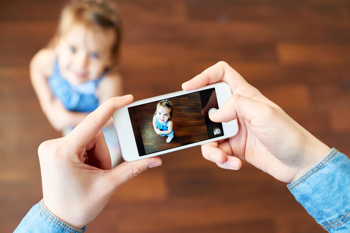 Kind wird mit Smartphone fotografiert