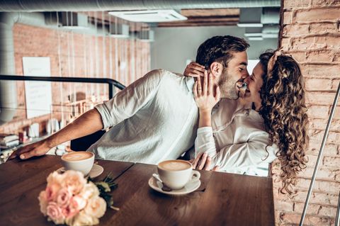 Was erwarten selbstbewusste Frauen in der Beziehung: Eine selbstbewusste Frau zieht ihren Mann zu sich rüber und küsst ihn