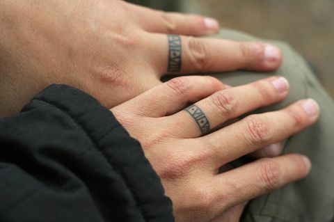 Partner Tattoo: Ein Paar mit tätowierten Ringen auf den Fingern