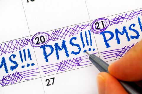 PMS: Frau trägt PMS in den Kalender ein