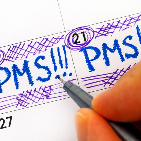 PMS: Frau trägt PMS in den Kalender ein