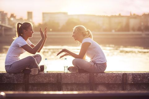 So bereichern Krebse unser Leben: Zwei Frauen sitzen auf einer Mauer vor einem großen Gewässer