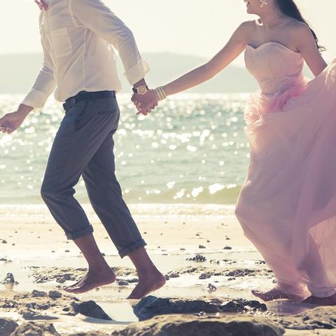 Freie Trauung: Braut und Bräutigam rennen am Strand entlang