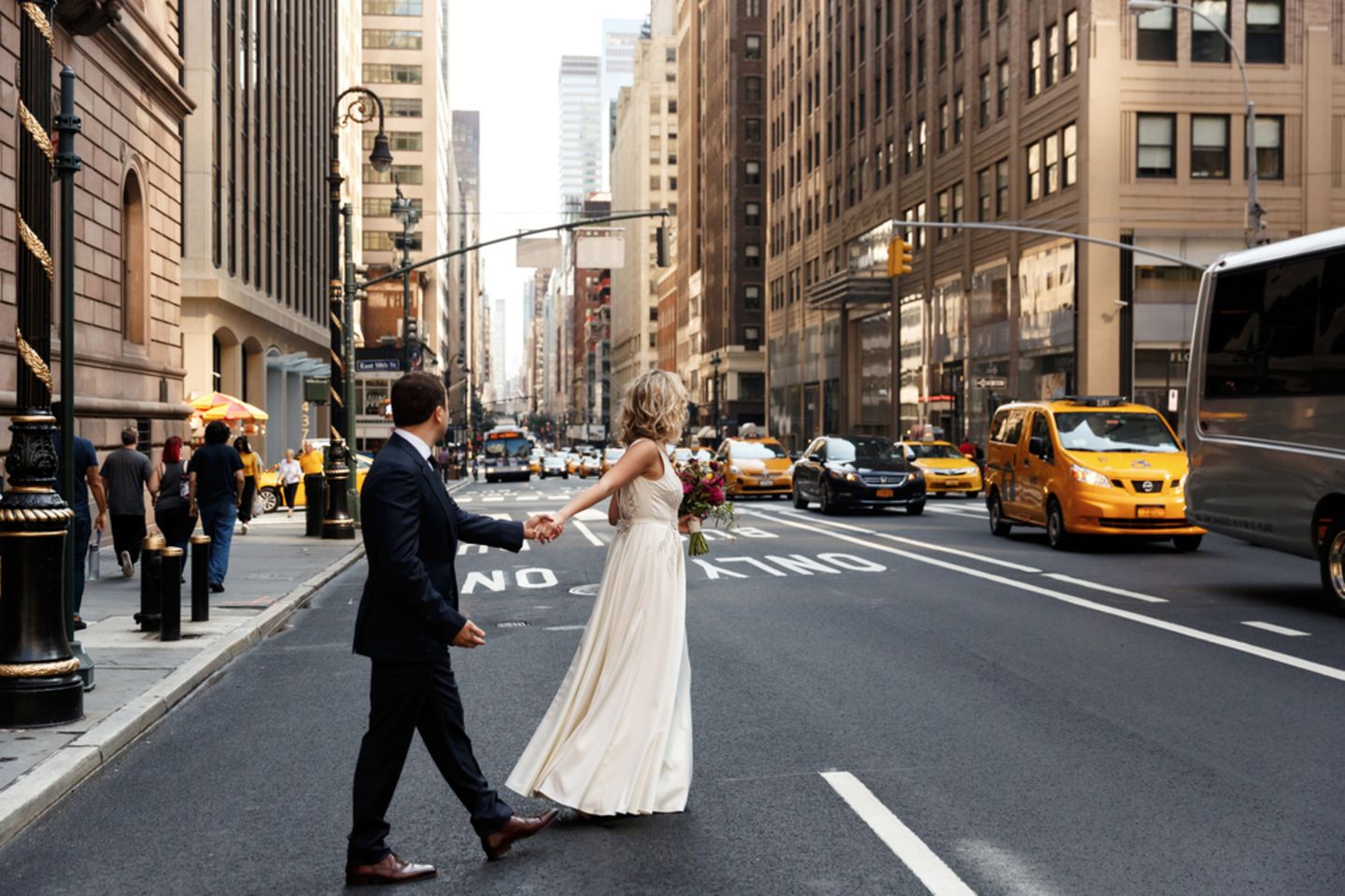 Heiraten im Ausland: Tipps für eure Traumhochzeit: Brautpaar geht in New York City über die Straße