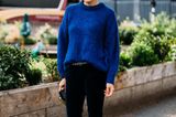 Outfits, die wir zur Arbeit anziehen: Frau mit blauem Pullover und schwarzer Hose