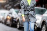 Outfits, die wir zur Arbeit tragen: Frau mit Neon-Pullover und Karoblazer