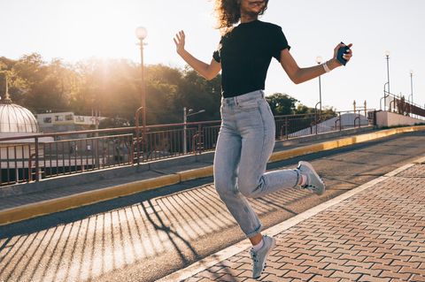 Ribcage Jeans: Frau springt vor Freude in die Höhe