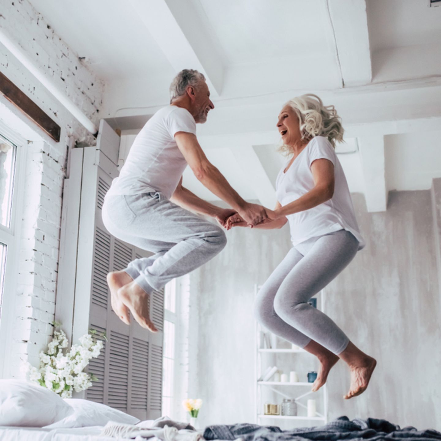 Eheversprechen: praktische Tipps und Beispiele: älteres Paar springt auf dem Bett auf und ab