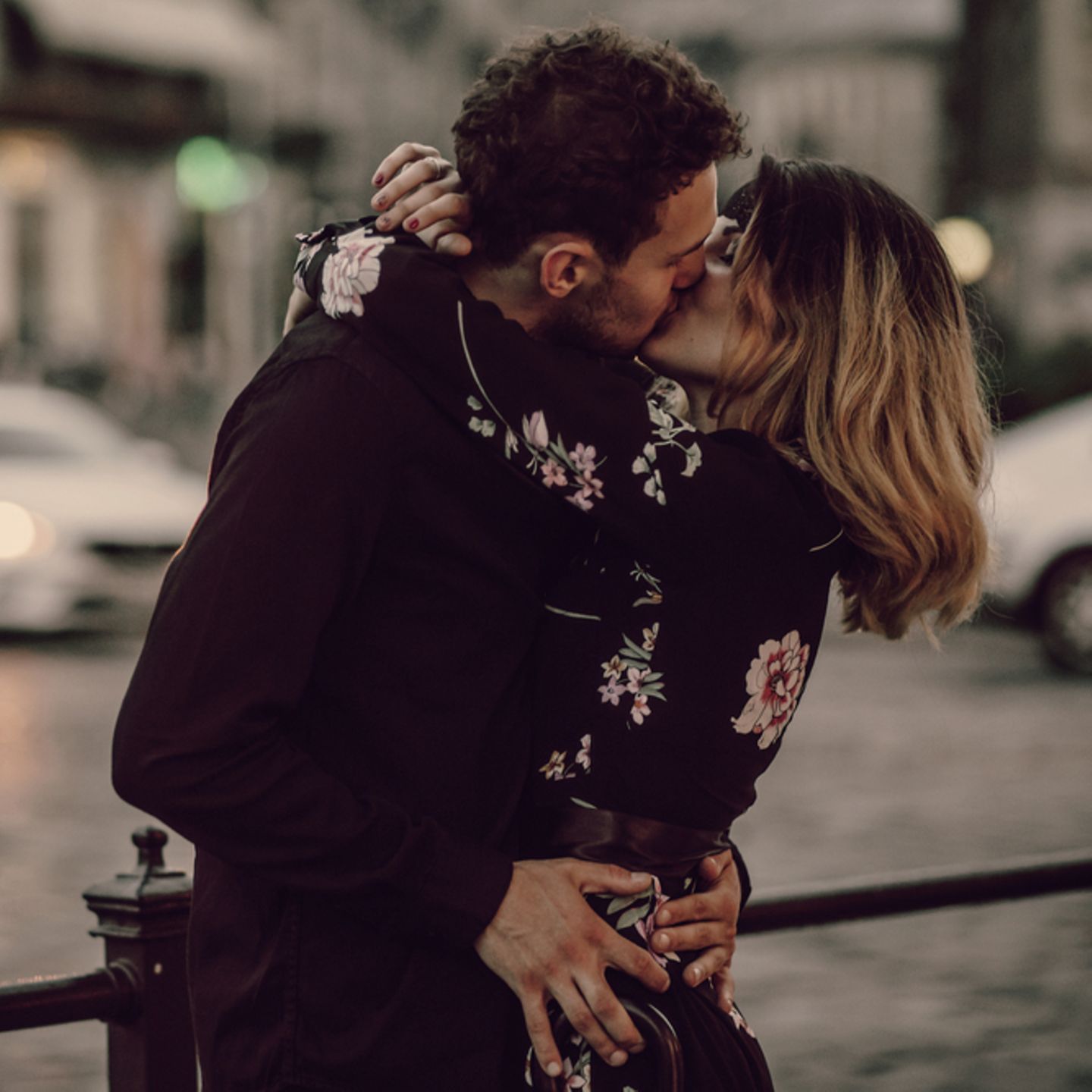 Eheversprechen: praktische Tipps und Beispiele: Paar küsst sich, dahinter verschwommene Straße und Autos