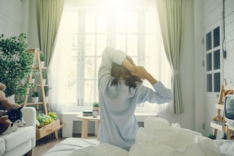Studie: Eine Frau reckt sich auf dem Bett
