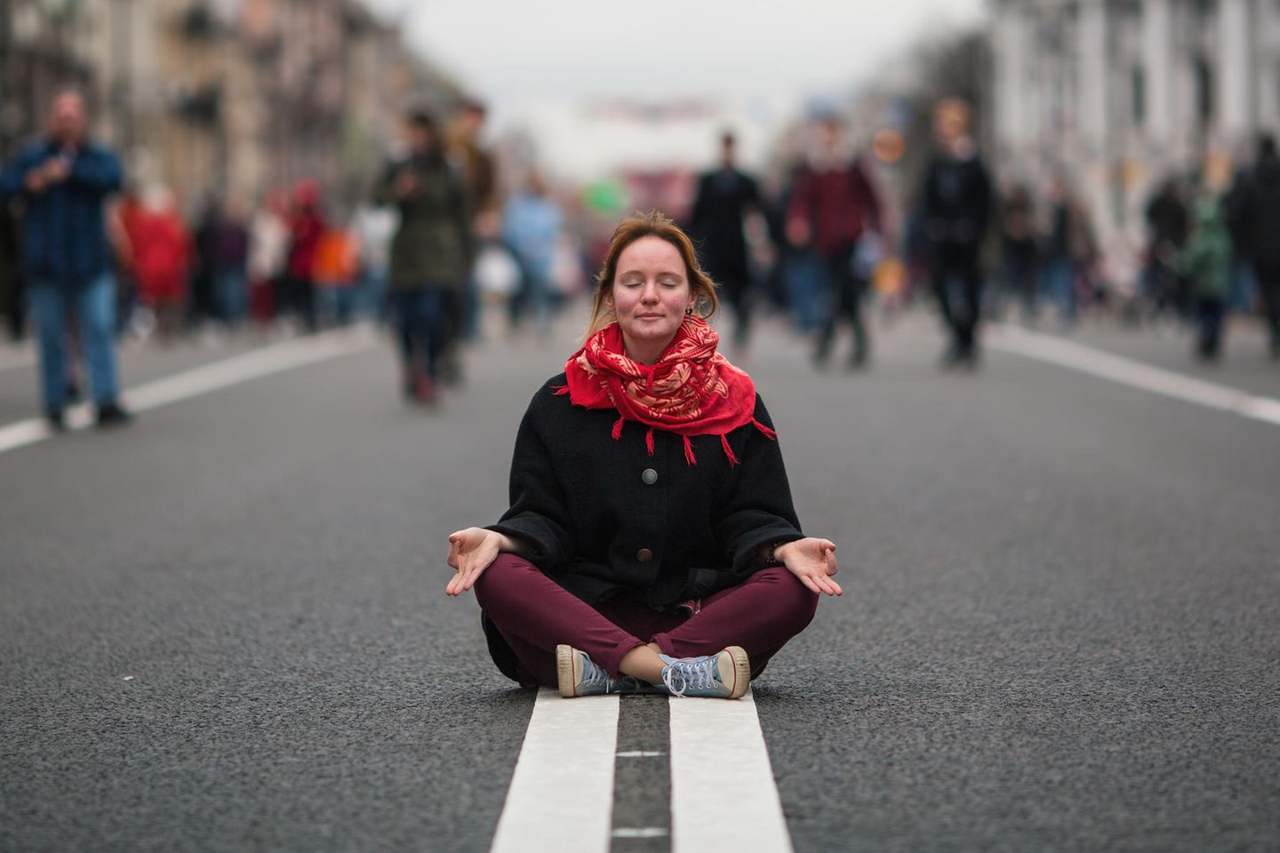 Genervt von anderen? Eine Frau meditiert auf der Straße
