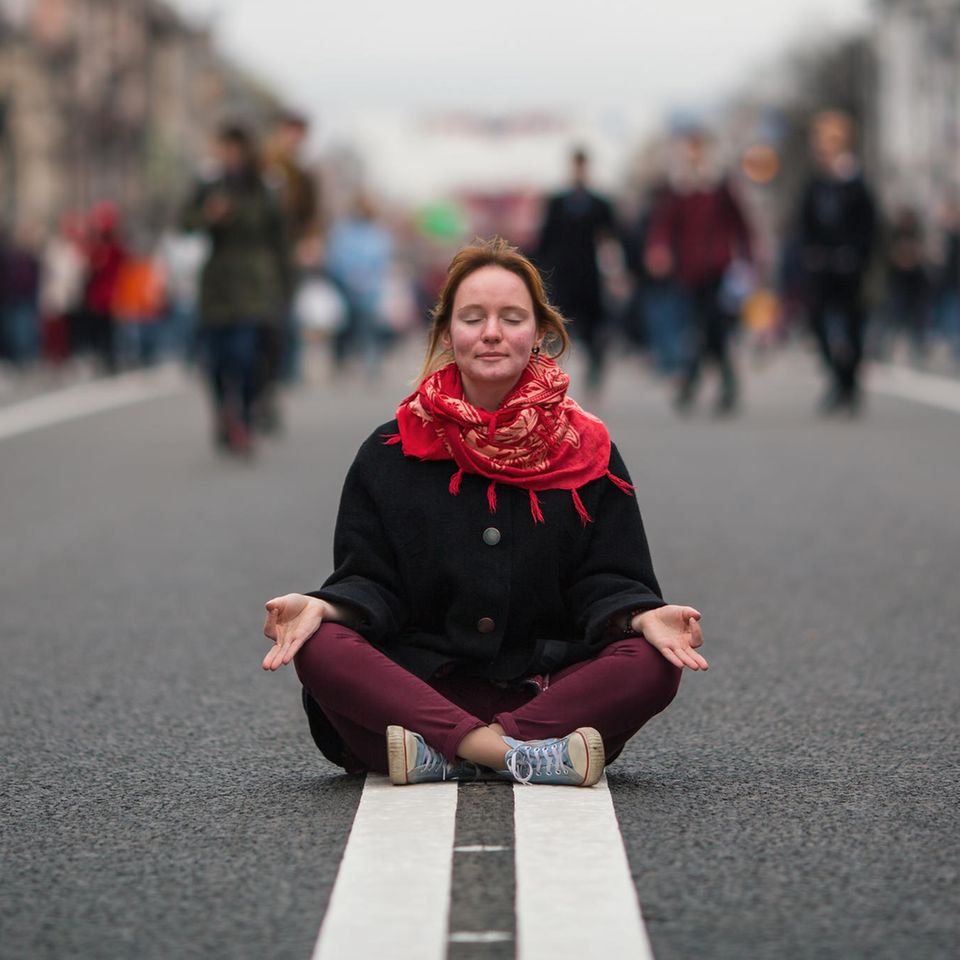 Genervt von anderen? Eine Frau meditiert auf der Straße