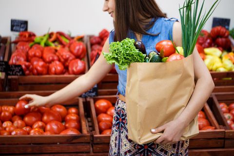 Ausgewogene Ernährung: Frau mit Einkaufstüte am Gemüsestand