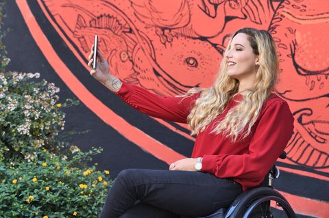 Frau im Rollstuhl macht ein Selfie von sich
