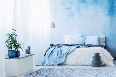 Wandgestaltung Schlafzimmer: 6 kreative Ideen: Bett in blau und weiß vor blau-weißer Wand