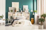 Wandgestaltung Schlafzimmer: 6 kreative Ideen: Bett vor einer kleinen Bücherwand und grüner Wandfarbe