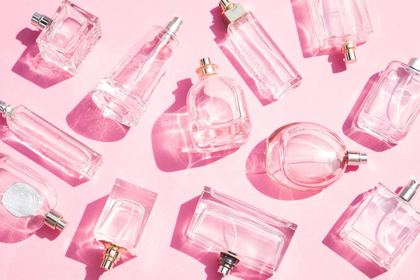 Parfum selber machen: Ganz viele Parfumflakons vor rosafarbenem Hintergrund