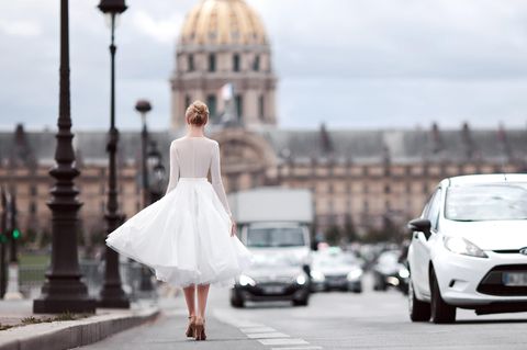 Dieses Brautkleid lieben alle Französinnen: Frau in kurzem Brautkleid läuft in Paris