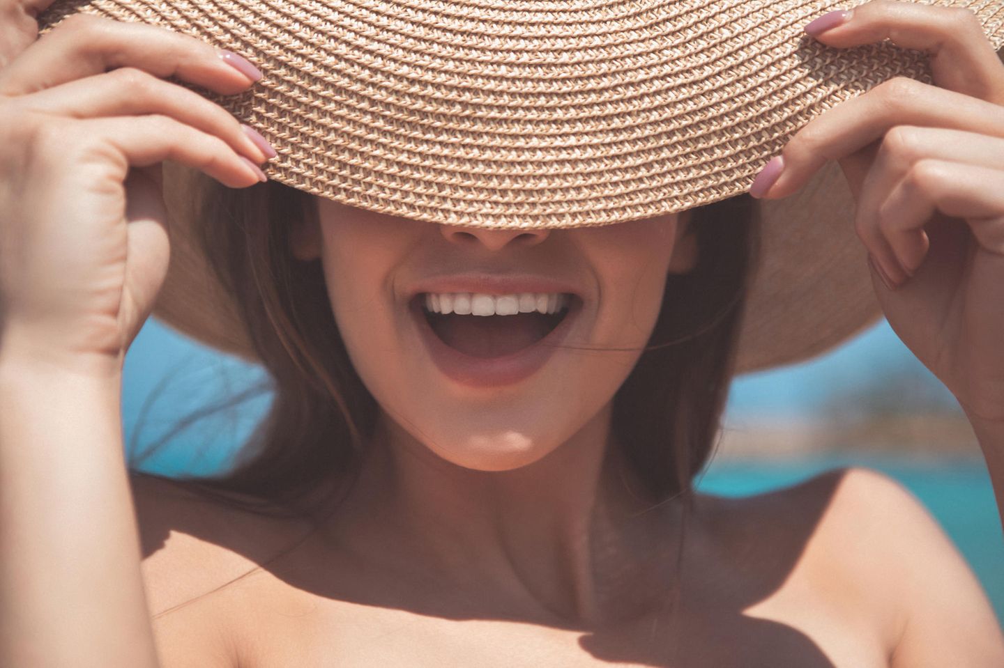 Sommervorbereitung: Frau mit Sonnenhut lächelt