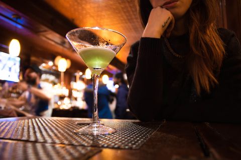 Was sind schlechte Dates? Frau sitzt in Bar vor ihrem Cocktail Glas