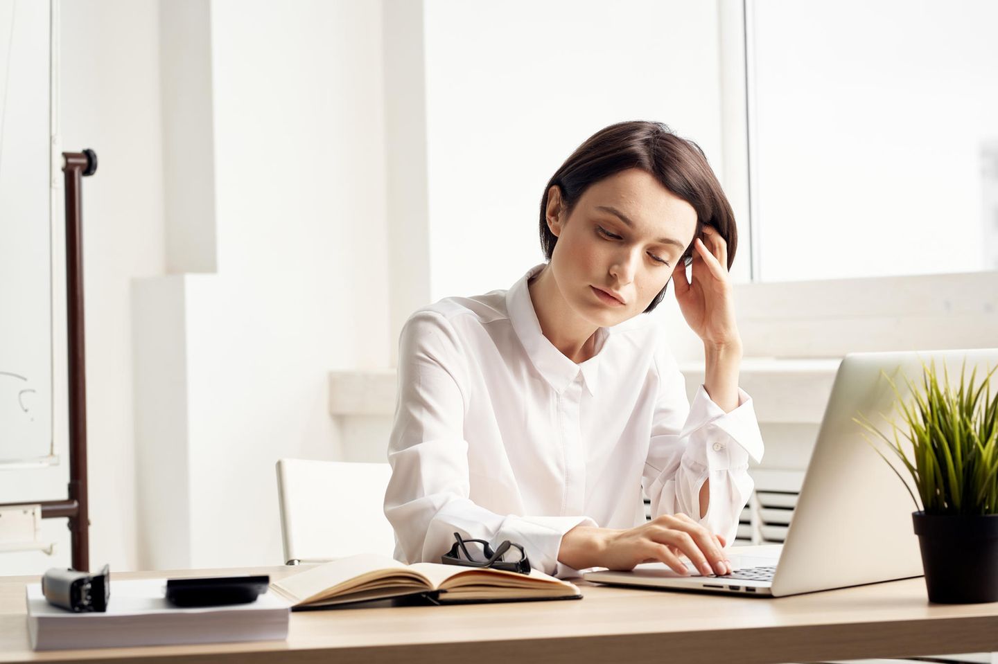 Müde Augen: Frau am Schreibtisch sieht müde aus