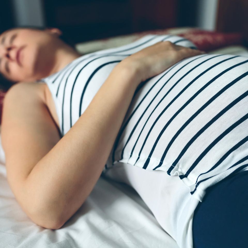 Listerien Schwangerschaft: Schwangere liegt auf Bett