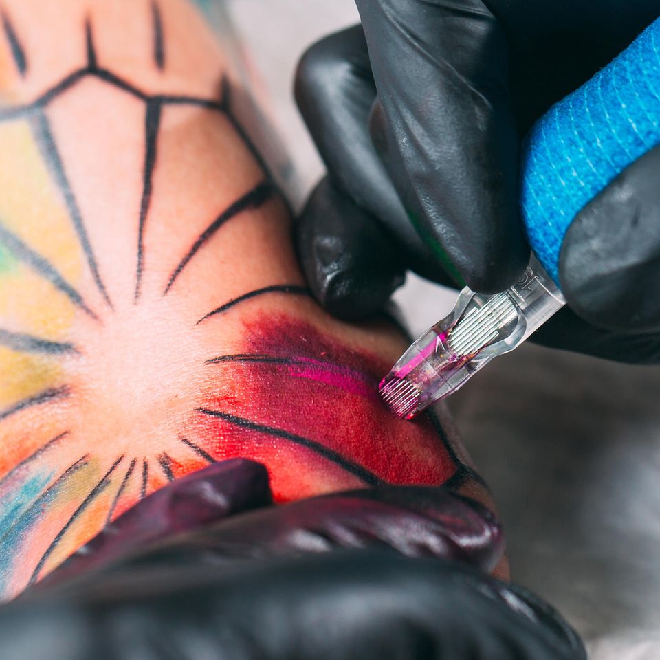 Watercolor Tattoo: Tättowierer sticht das Tattoo