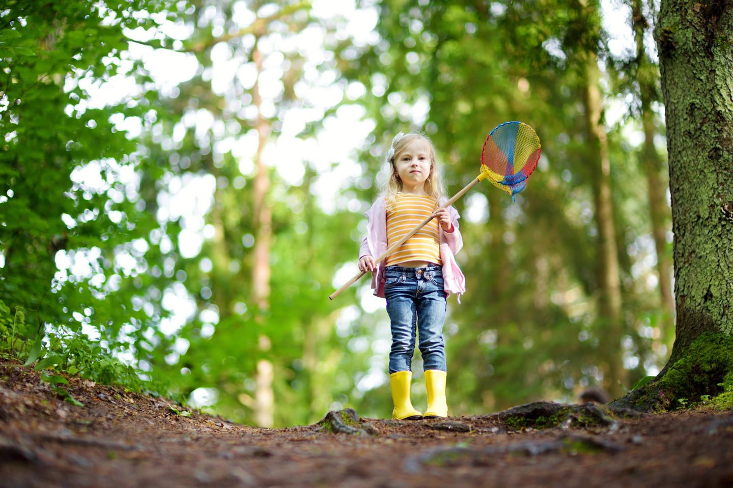Kindererziehung: Mädchen mit Windrad im Wald