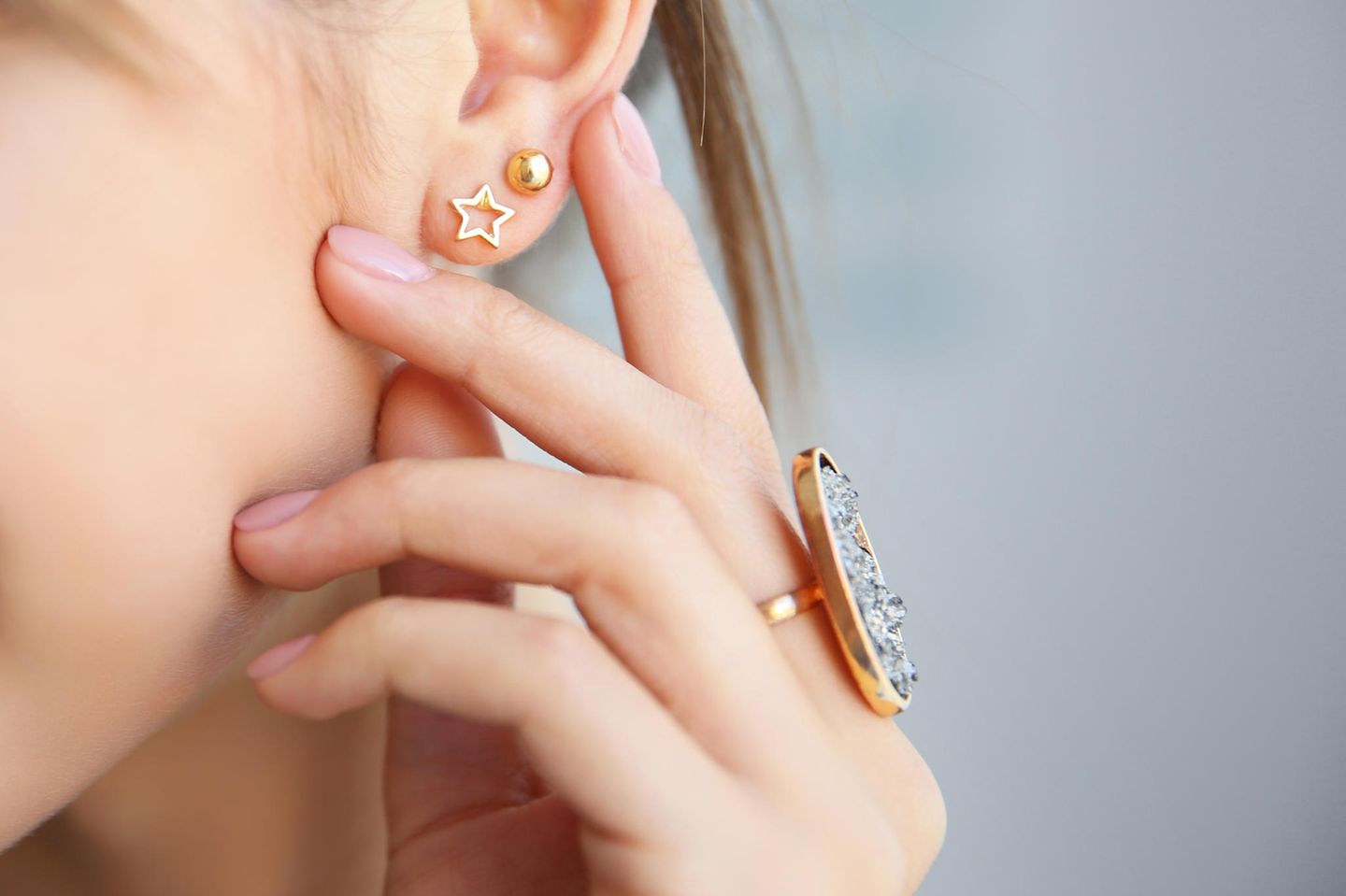 High Lobe: Frau mit Ohrringen und großem Ring am Finger