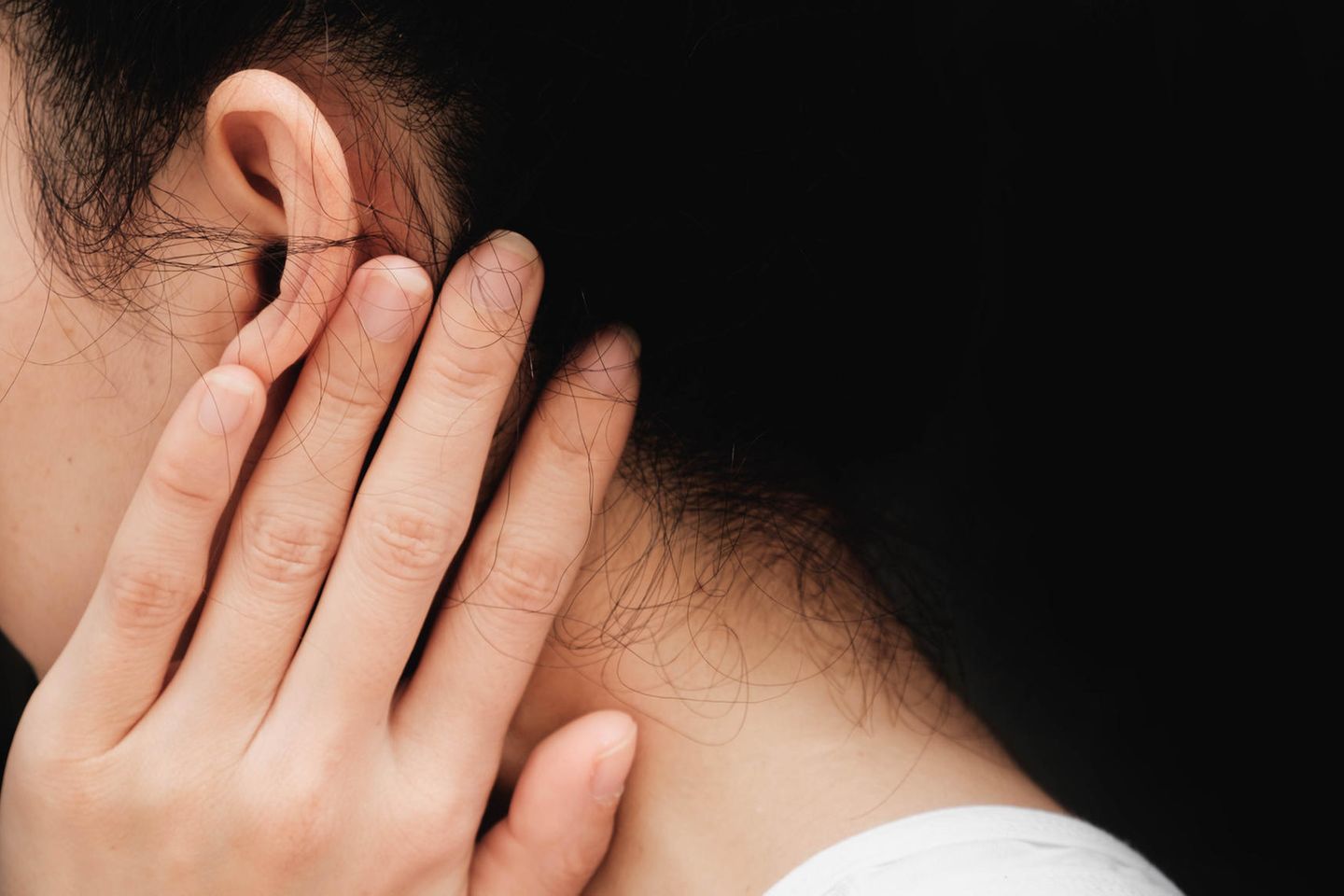 Hausmittel gegen Ohrenschmerzen: Frau hält Hand ans Ohr