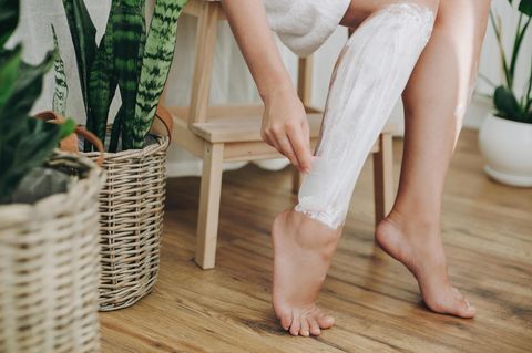 Enthaarungscreme: Frau enthaart sich die Beine mit einer Enthaarungscreme