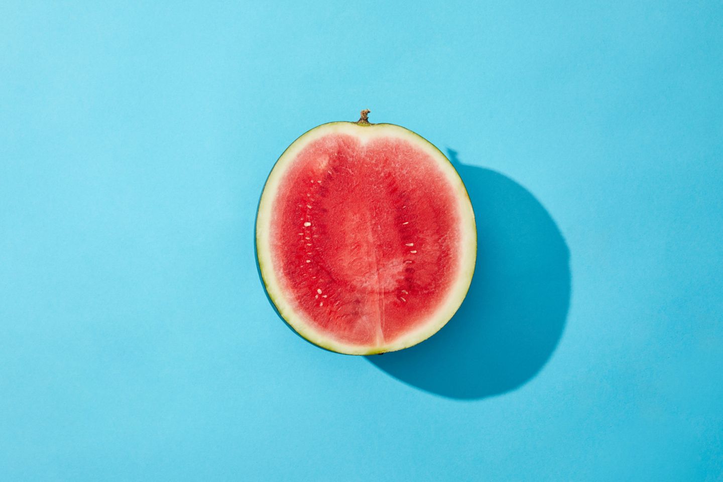 Nach hinten gekippte Gebärmutter: Halbe Melone vor blauem Hintergrund