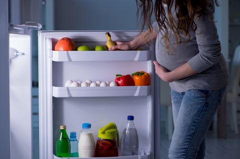 Was dürfen Schwangere nicht essen: Schwangere Frau am Kühlschrank