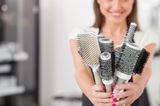 Haarpflege: Frau hält Haarbürsten in den Händen