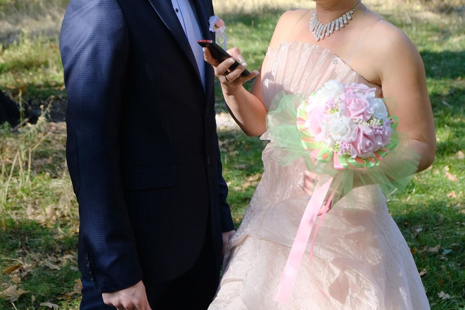 Fremdgehen: Bräutigam und Braut mit Handy