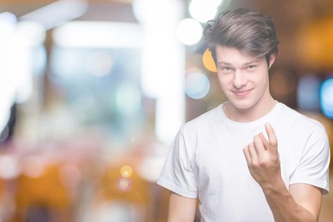 Catcalling: Ein junger Mann deutet mit dem Zeigefinger, man solle zu ihm kommen