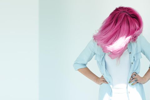Haare entfärben: Die besten Tipps und Hausmittel: Frau mit rosafarbenen Haaren schüttelt ihr Haar nach vorne