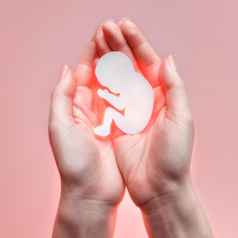 Kinderwunsch: Mediziner empfehlen Änderungen für das Embryonenschutzgesetz: Frau hält Symbol für Embryo in ihren Händen