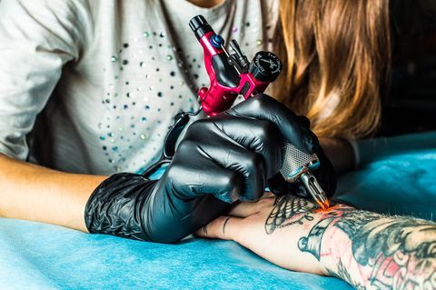 Tatto Motive: Frau bekommt Tattoo am Arm