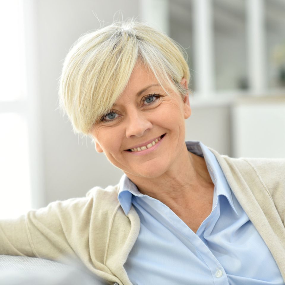Kurzhaarfrisuren für Frauen ab 50: Frau mit blonder Kurzhaarfrisur lächel.....