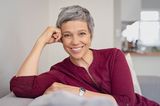 Kurzhaarfrisuren für Frauen ab 50: Frau mit kurzen grauen Haaren lächelt offen