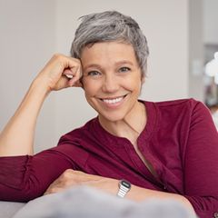 Kurzhaarfrisuren für Frauen ab 50: Frau mit kurzen grauen Haaren lächelt offen