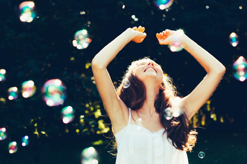 WOOP: Eine fröhliche Frau fängt Seifenblasen